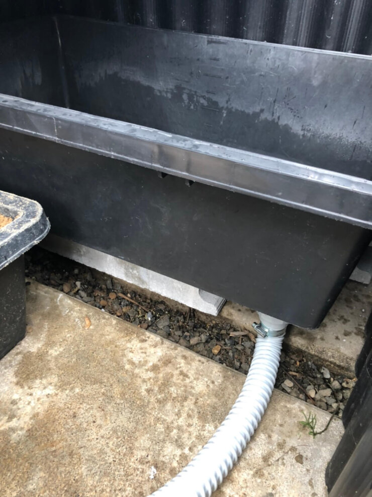 プラ箱に排水用の栓を取り付ける作業(イシガメ)